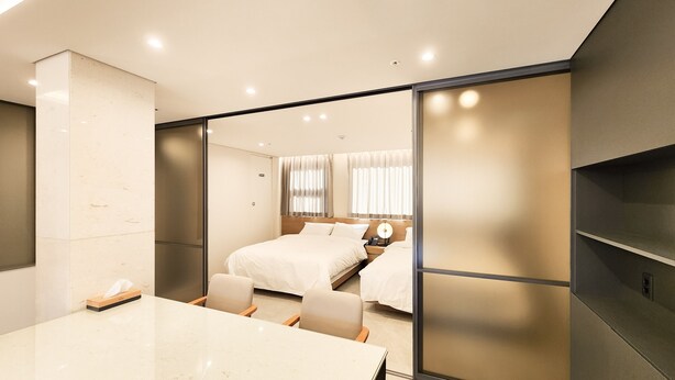 Una habitación de hotel moderna con una cama grande, un escritorio y una puerta corredera.