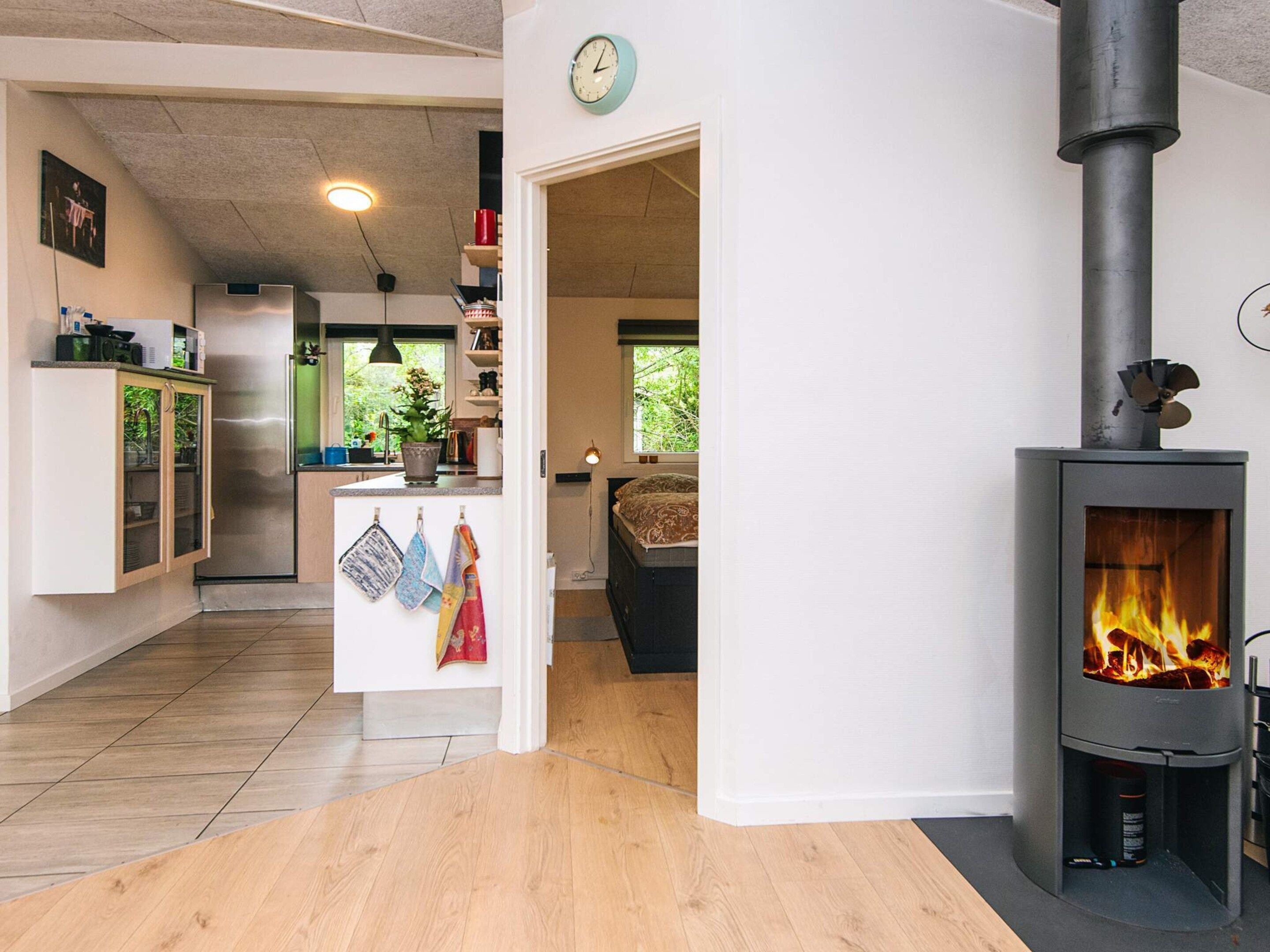 A modern kitchen with a central island, a built-in stove, and a dining area with a sofa and table.
