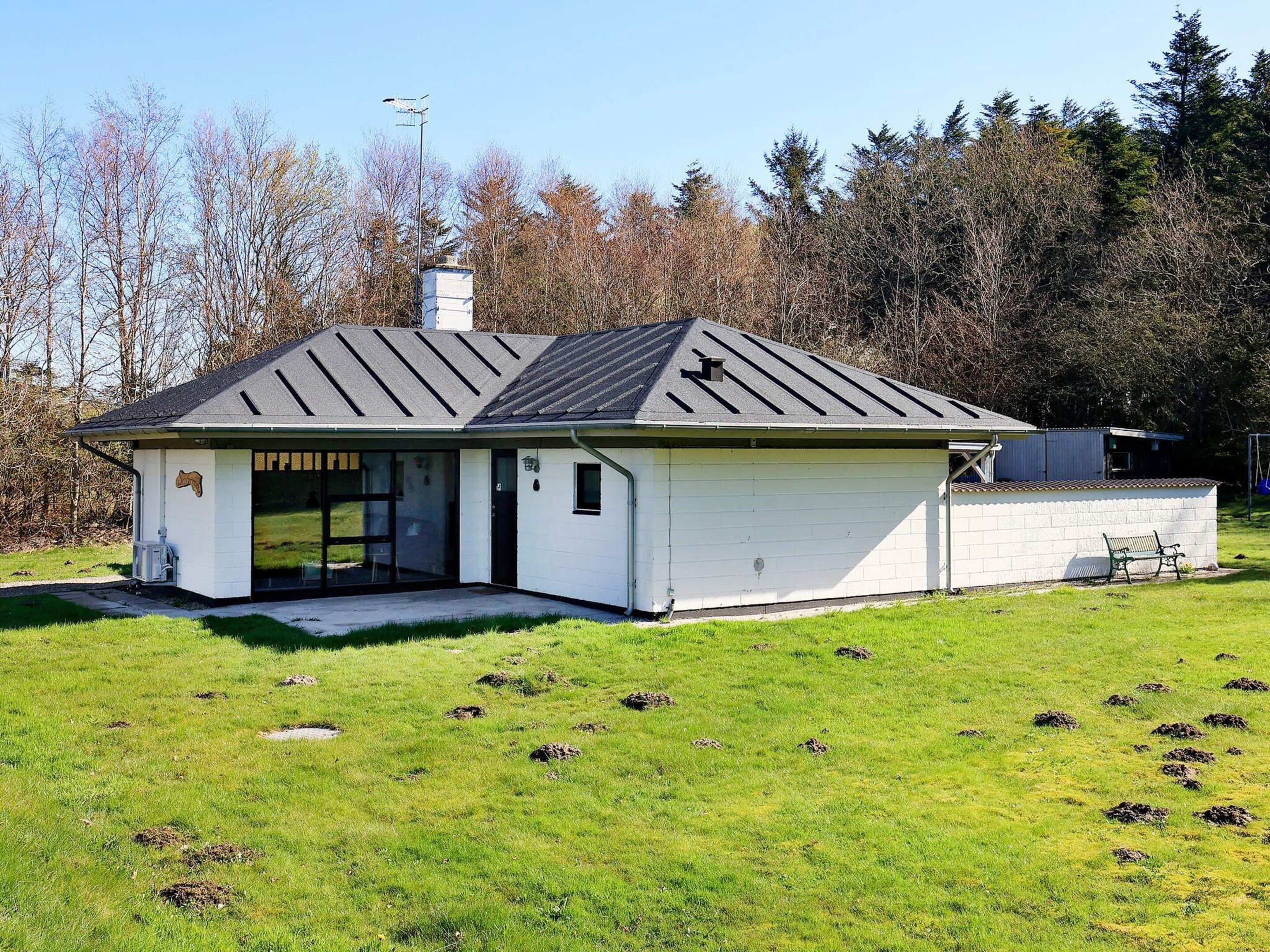 A single-story building with a sloped roof, a garage, and a small porch area.