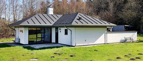 A single-story building with a sloped roof, a garage, and a small porch area.