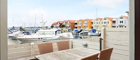 A view from a balcony overlooking a marina with boats and colorful buildings in the background.