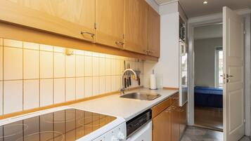 A modern kitchen with wooden cabinets, a stainless steel sink, and a built-in dishwasher.