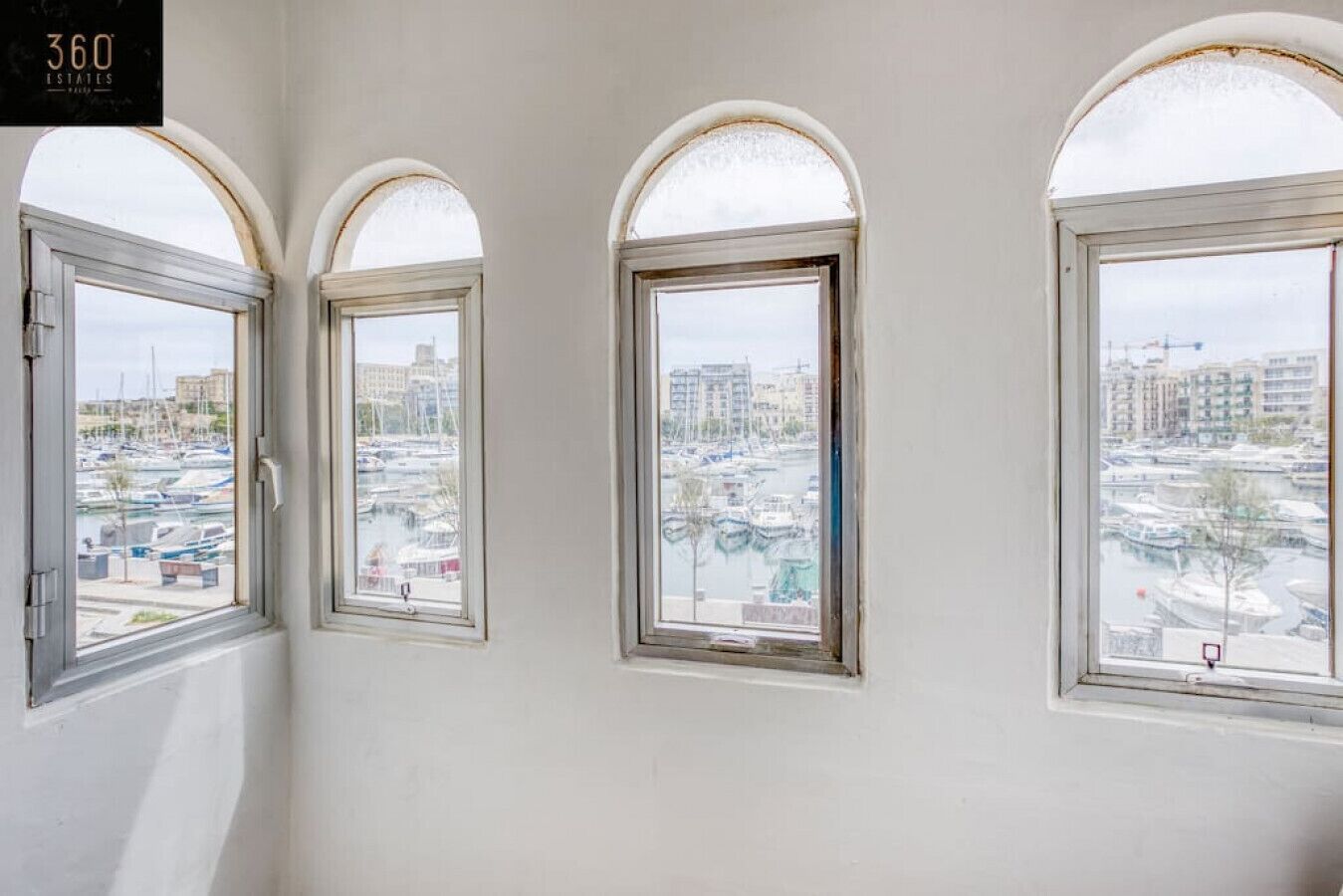 Three arched windows with a marina view.