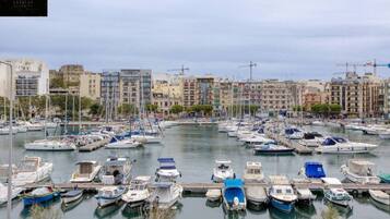A marina with numerous boats docked, surrounded by multi-story buildings.