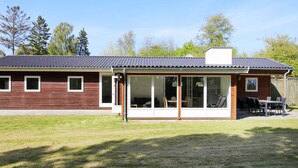 A two-story house with a large glass door leading to a patio area. - 6 Person Holiday Home in Gilleleje (Gilleleje)