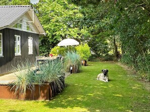 A house with a patio, a dog, and a garden.