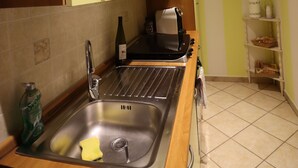 A kitchen with a sink, a toaster, and a clock on the wall. - B&B stella polare Rieti (Rieti)