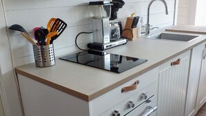 A compact kitchen with a built-in stove, a coffee maker, and a sink. - 7 Person Holiday Home in Aros (Asker)