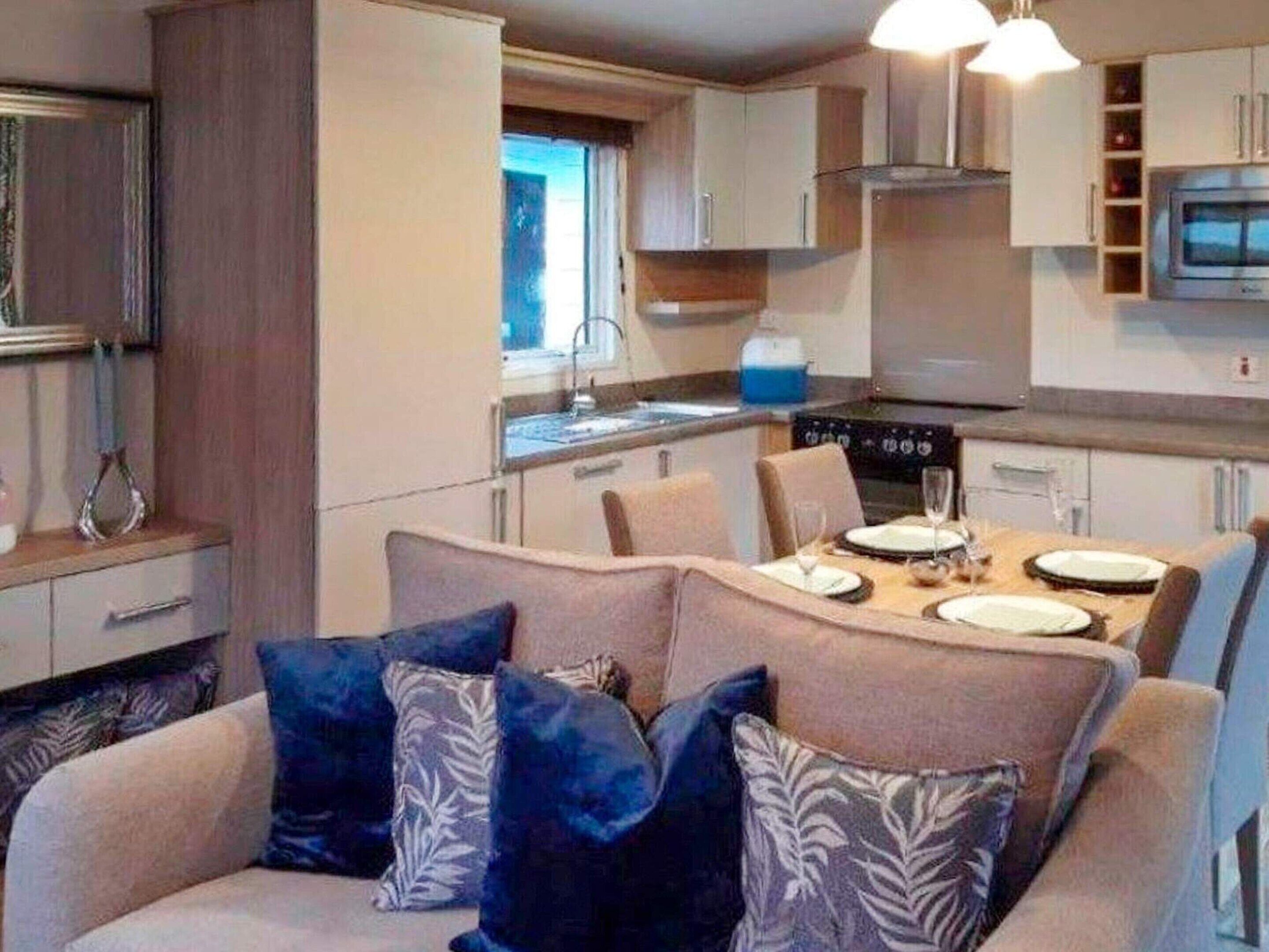 A compact kitchen with a dining area, a microwave, and a stove.