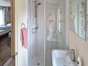 A bathroom with a shower, a sink, and a mirror. - 6 Person Holiday Home in Tansoy (Kinn)
