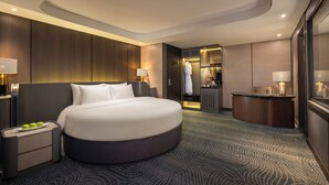 A modern hotel room with a large round bed, a desk, and a walk-in closet. - Doria Cruise (Tuan Chau)