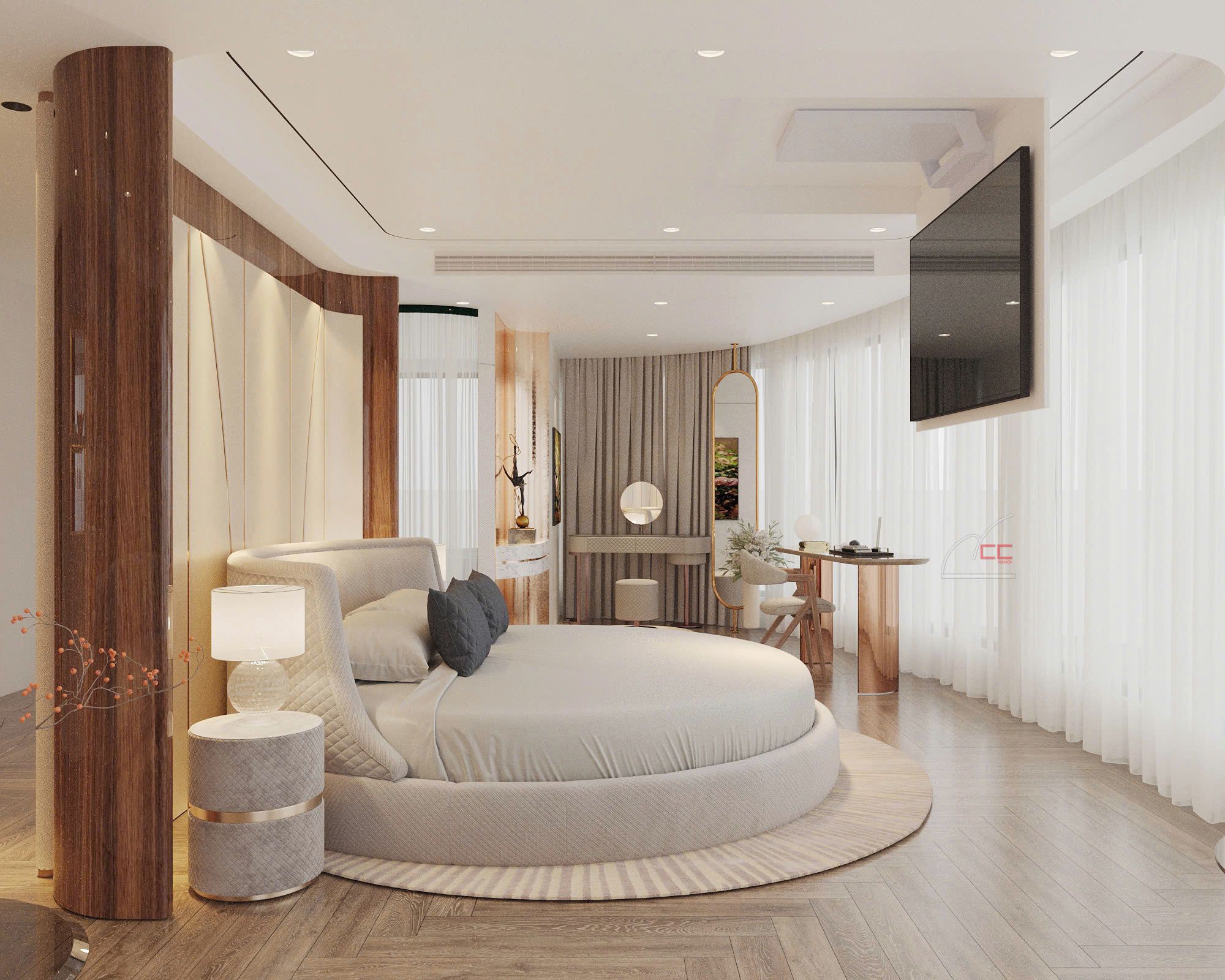 Quarto moderno com cama circular, televisão fixada na parede e pequeno espaço de escritório.