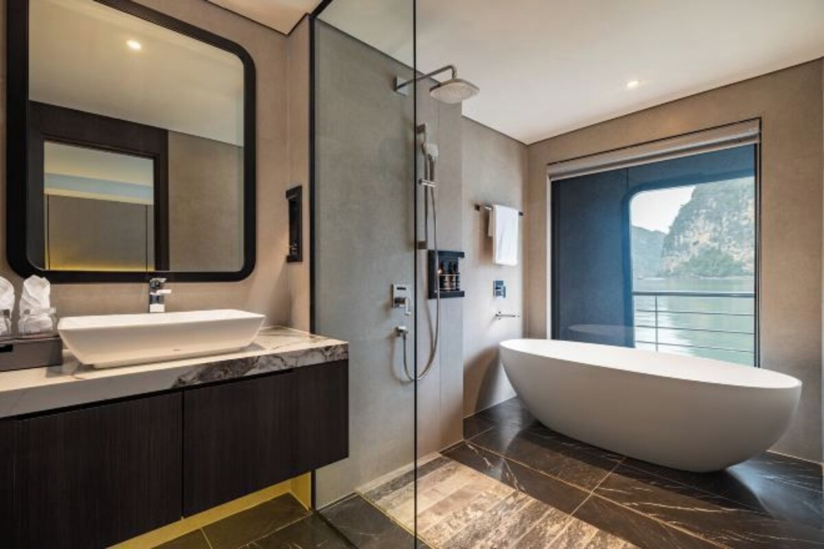Un baño moderno con una bañera grande, una zona de ducha separada y un espejo amplio.