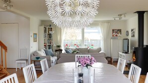 A dining area with a white table, chairs, and a decorative ceiling light. - 5 Star Holiday Home in Mellbystrand (Mellbystrand)