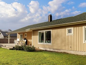 A single-story house with a porch, a chimney, and a well-maintained lawn. - 5 Star Holiday Home in Mellbystrand (Mellbystrand)