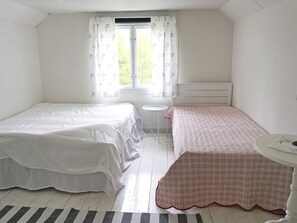 A bedroom with two beds, a small round table, and a window with curtains. - 6 Person Holiday Home in Hallabro-by Traum (Hallaröd)