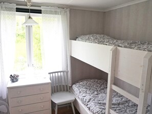 A bunk bed room with a desk and chair, a window with lace curtains, and a hanging light fixture. - 6 Person Holiday Home in Hallabro (Hallaröd)