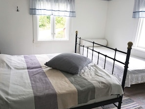 A bed with a metal frame and a window with a view of greenery outside. - 6 Person Holiday Home in Hallabro (Hallaröd)