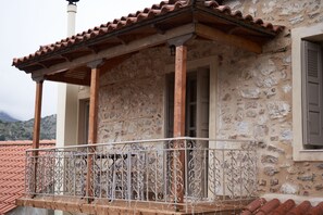 Un bâtiment en pierre doté d’un balcon orné de balustrades en métal ouvragé.