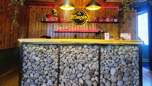 A bar with a wooden interior, a neon sign, and a counter with a unique stone design. - The Hotel Nanglo (Taplejung)