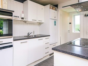 A modern kitchen with white cabinetry, a built-in oven, a sink, and a stove. - 5 Person Holiday Home in Odder (Odder)