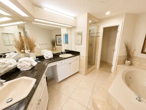 Une salle de bain moderne dotée d’un grand lavabo, d’une baignoire, d’une douche et d’un meuble-lavabo avec un miroir.