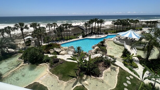 Ein Resort mit Pool, Strand und Palmen.