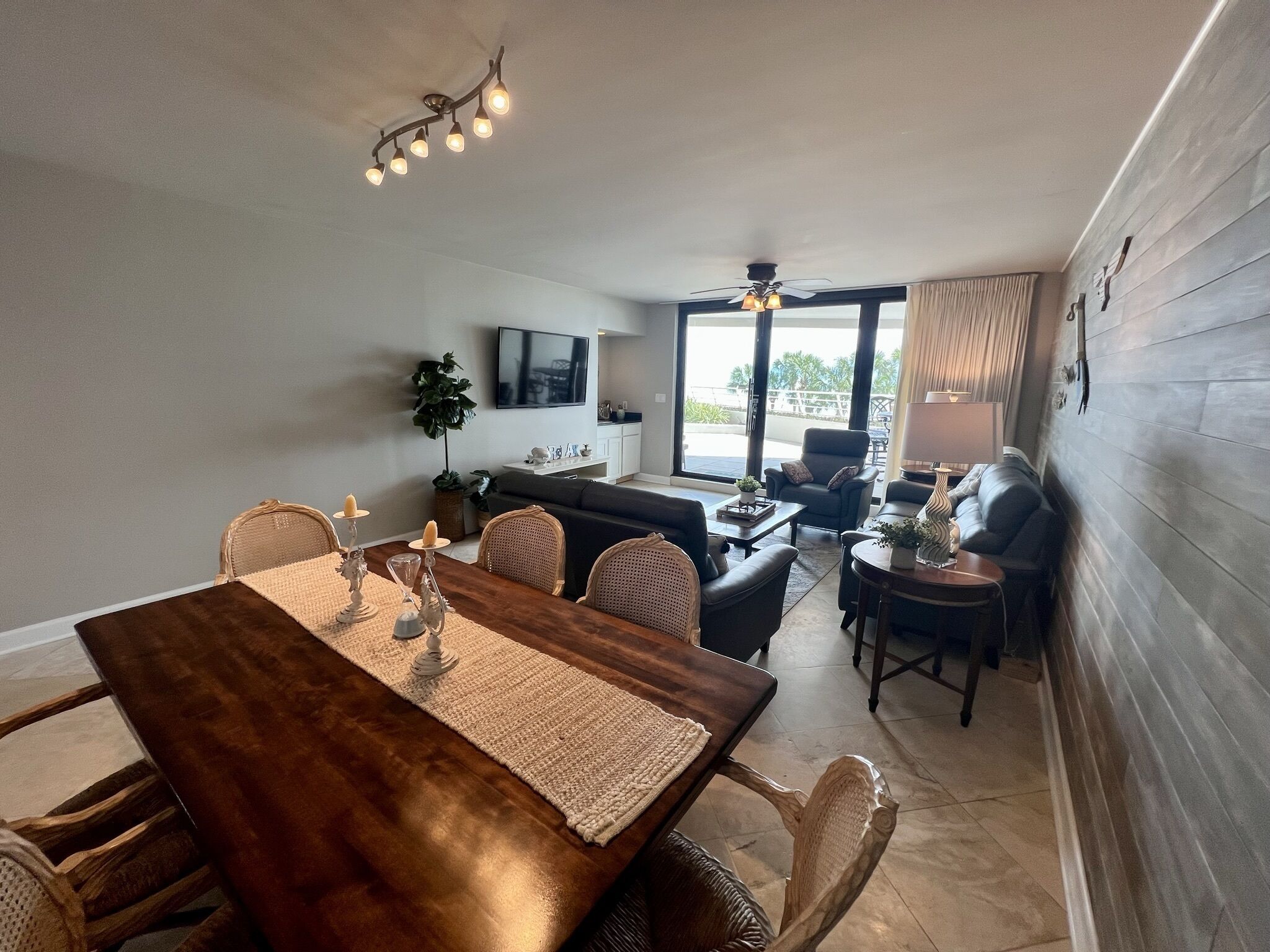 Un espace repas comprenant une table en bois, des chaises et un luminaire suspendu au plafond.