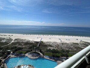 A beach view with a pool and lounge chairs. - West 1102 2 Bedroom Gulf Front Condo with Stunning Views! (Pensacola)