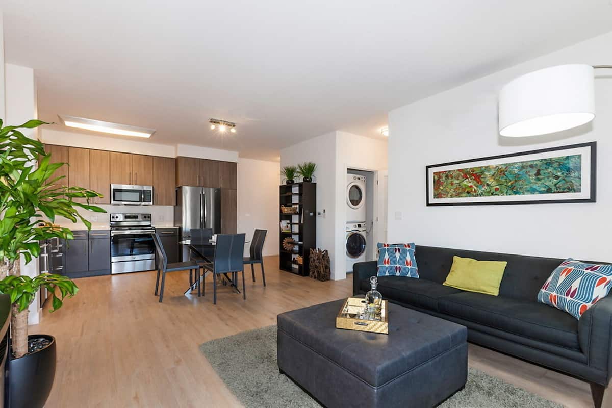 A modern apartment with a kitchen, dining area, and living room.