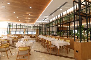 A spacious dining area with multiple tables and chairs, a wooden ceiling, and large windows allowing natural light. - Siu Collection Ultra All Inclusive (Kemer)