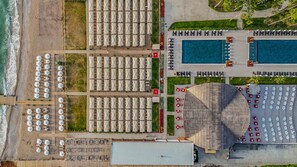 An aerial view of a resort with multiple swimming pools, beachside umbrellas, and lounge areas. - Siu Collection Ultra All Inclusive (Kemer)