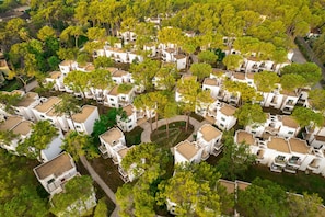 Vista aérea de una zona residencial con casas blancas rodeadas de árboles.