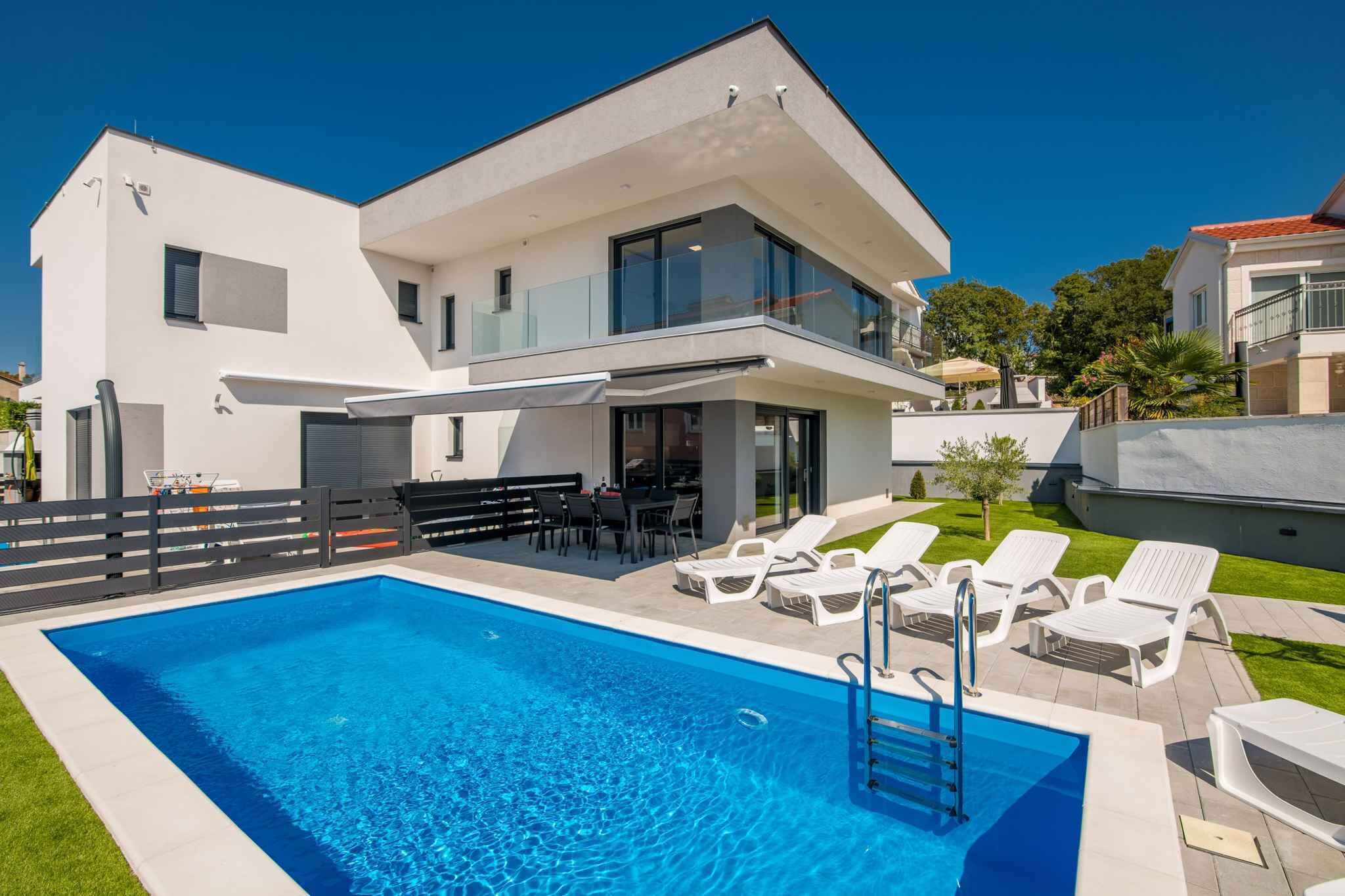 Een modern huis met twee verdiepingen, een zwembad, terras en een balkon.