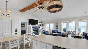A spacious kitchen with a large island, white cabinetry, and a ceiling fan. - Oceanfront Bliss - Spacious Beach Cottage for up to 11 Guests (Surf City)