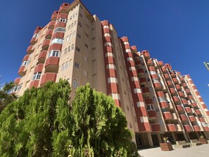 Stunning multi-story building with balconies and lush green surroundings.