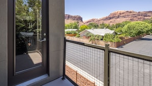 Un balcon donnant sur un quartier résidentiel et une chaîne de montagnes.