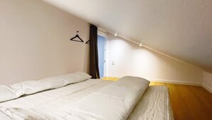 A bedroom with a bed, a hanging light fixture, and a door. - 14 Person Holiday Home in Vaeggerlose (Vaeggerlose)