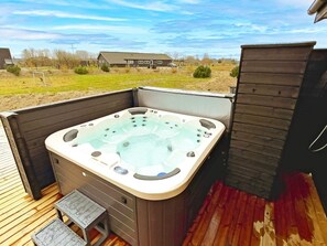 A hot tub on an outdoor deck with a view of a residential area. - 14 Person Holiday Home in Vaeggerlose (Vaeggerlose)