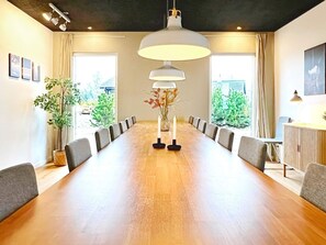A conference room with a long table, chairs, a white lamp, and a potted plant. - 14 Person Holiday Home in Vaeggerlose (Vaeggerlose)