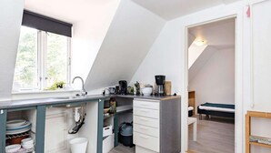 A compact kitchen with a window, a sink, and a coffee maker. - 3 Person Holiday Home in Aeroskobing (Aeroskobing)