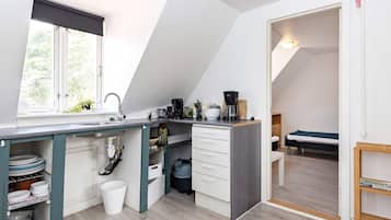 A compact kitchen with a window, a sink, and a coffee maker.