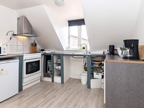 A compact kitchen with a built-in oven, a stovetop, and a coffee maker. - 3 Person Holiday Home in Aeroskobing (Aeroskobing)
