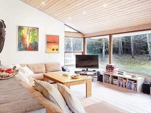Een moderne woonkamer met een bank, salontafel, televisie en boekenkasten.