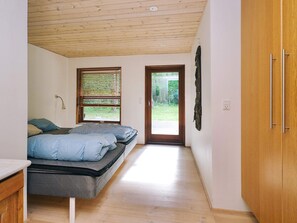 Une chambre à coucher avec un lit, une fenêtre et une porte donnant sur l’extérieur.