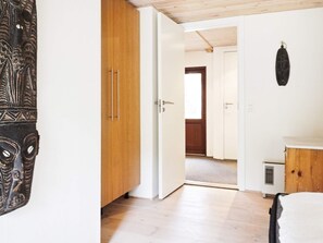 Et værelse med et træskab, en hvid dør og en lampe monteret på væggen.