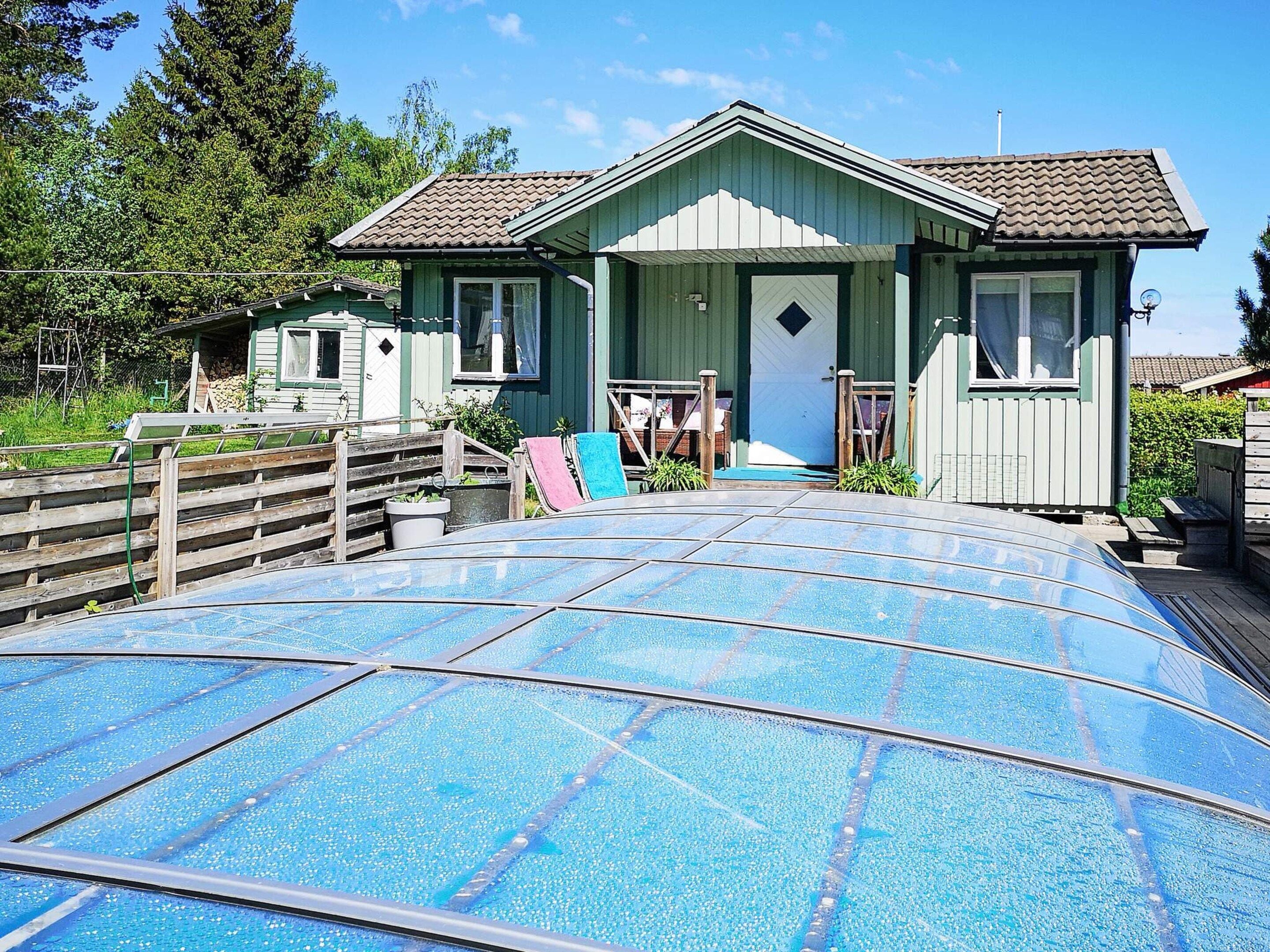 Een huis met een veranda, een garage en een zwembad.
