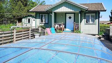 Een huis met een veranda, een garage en een zwembad.