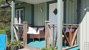 Une véranda abritée avec un coin salon, une piscine et des plantes en pot.