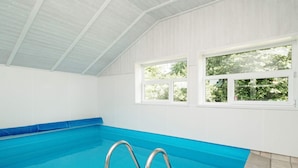 An indoor swimming pool with clear blue water, a tiled floor, and a metal ladder. - 7 Person Holiday Home in Graested (Gilleleje)